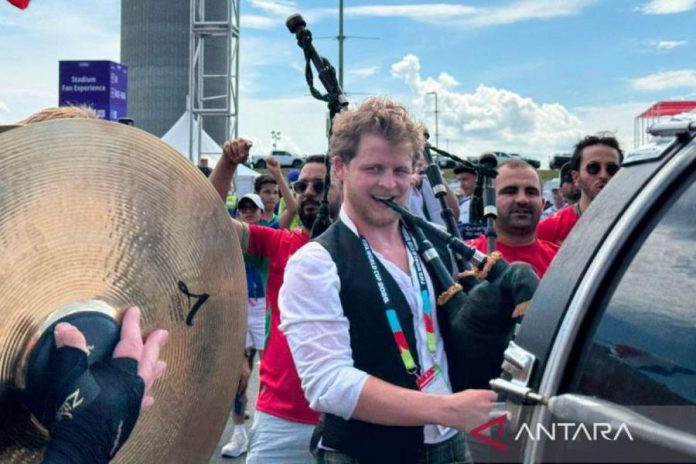 Suporter timnas Maroko bernyanyi diiringi alat musik Skotlandia di Boston Suporter timnas Maroko bernyanyi diiringi alat musik Skotlandia di Boston